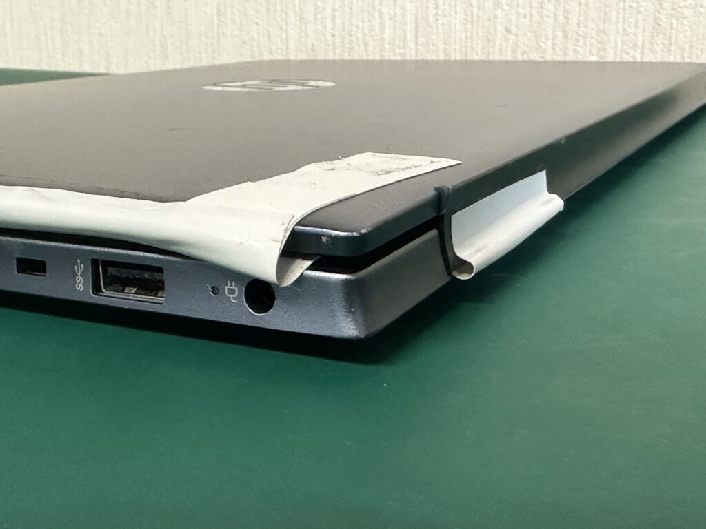 預かったパソコンの状態。白のビニールテープで補強されています。